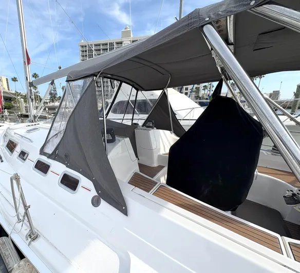 Bylgja Yacht Photos Pics 2005 Hunter 38 sailboat with canopy, docked in a marina under clear skies.