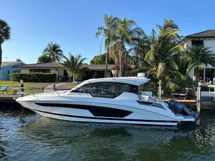 Olivia Yacht Photos Pics 2020 Four Winns Vista 355 Coupe docked by a waterfront home with palm trees.
