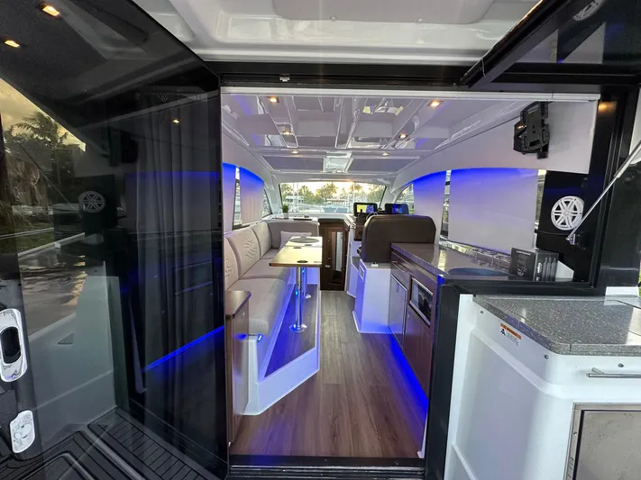 Olivia Yacht Photos Pics 2020 Four Winns Vista 355 Coupe interior with modern design, blue LED lighting, and wood flooring.