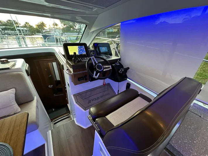 Olivia Yacht Photos Pics 2020 Four Winns Vista 355 Coupe cockpit with modern navigation systems and leather seating.