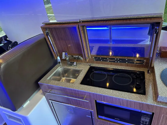 Olivia Yacht Photos Pics 2020 Four Winns Vista 355 Coupe kitchen with sink, stove, and microwave.