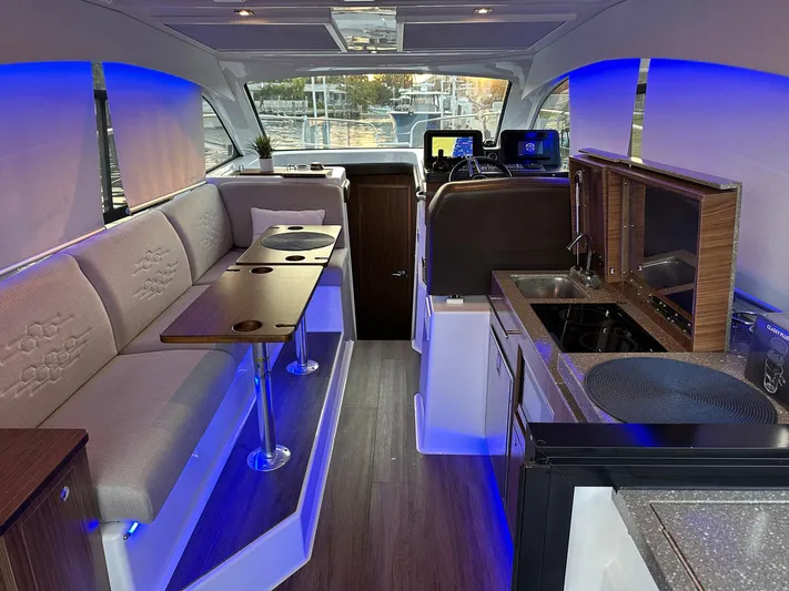 Olivia Yacht Photos Pics Interior of 2020 Four Winns Vista 355 Coupe with modern seating and kitchen area.