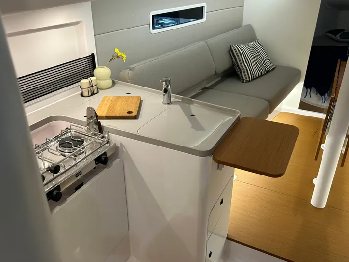  Yacht Photos Pics Modern interior of 2025 Beneteau First 30 yacht with compact kitchen and seating area.