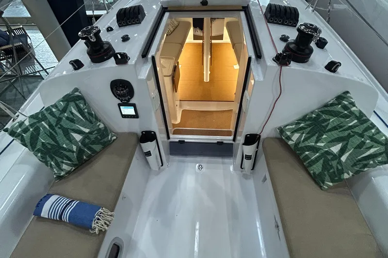  Yacht Photos Pics 2025 Beneteau First 30 sailboat cockpit with cushions and cabin view.