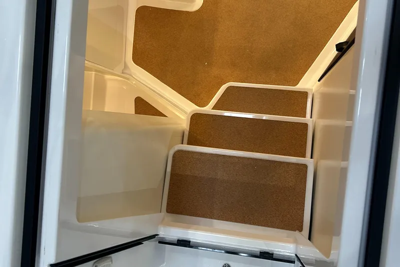  Yacht Photos Pics Staircase inside 2025 Beneteau First 30 yacht with brown carpeted steps.