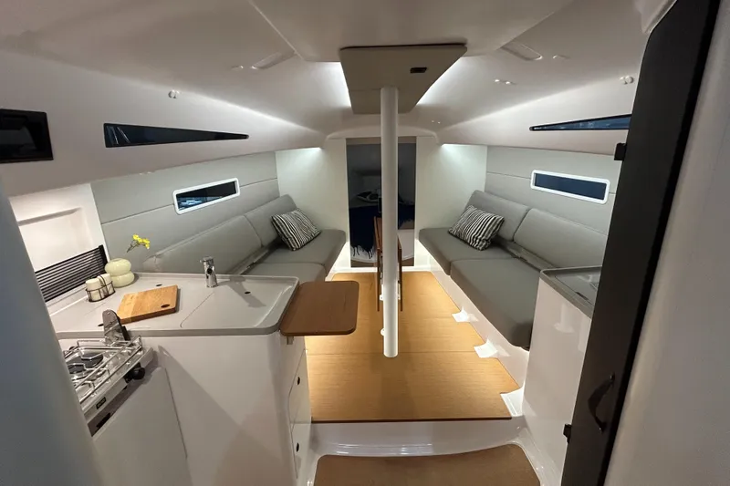  Yacht Photos Pics Interior of 2025 Beneteau First 30 sailboat, featuring modern design and cozy seating.