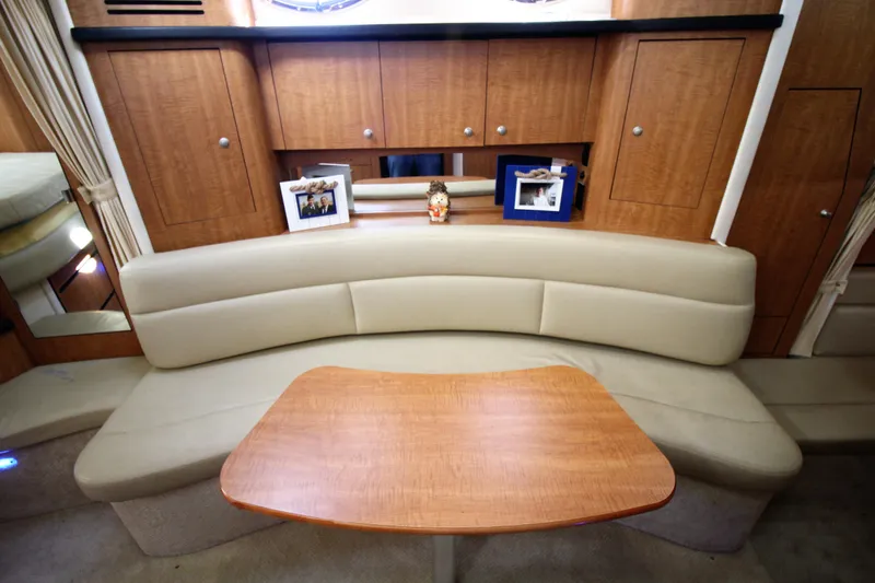  Yacht Photos Pics Interior of 2006 Sea Ray 340 Sundancer with beige seating and wooden table.