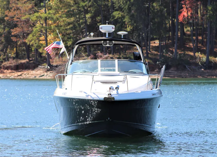  Yacht Photos Pics 2006 Sea Ray 340 Sundancer boat on a serene lake with forest backdrop.