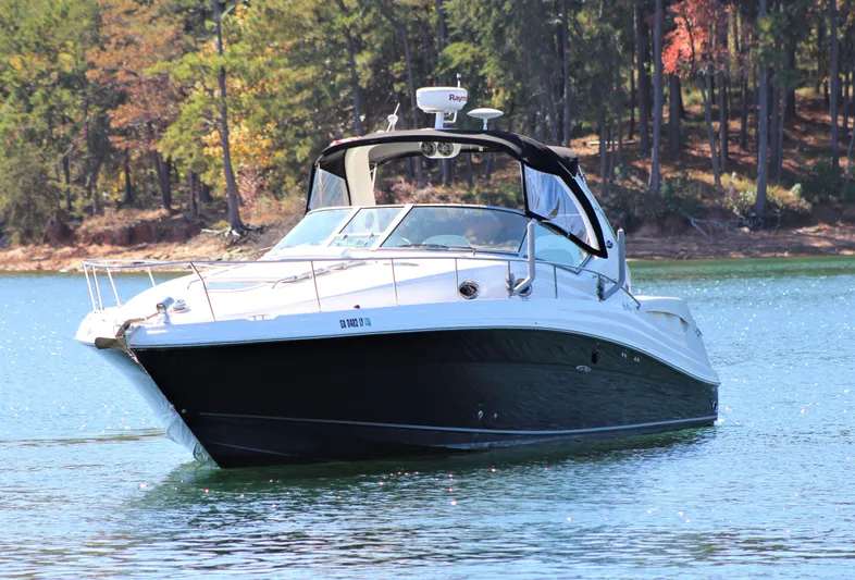  Yacht Photos Pics 2006 Sea Ray 340 Sundancer yacht cruising on a serene lake with forested background.