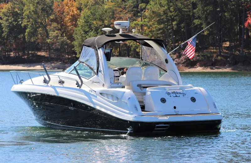  Yacht Photos Pics 2006 Sea Ray 340 Sundancer boat on a lake with American flag, surrounded by trees.