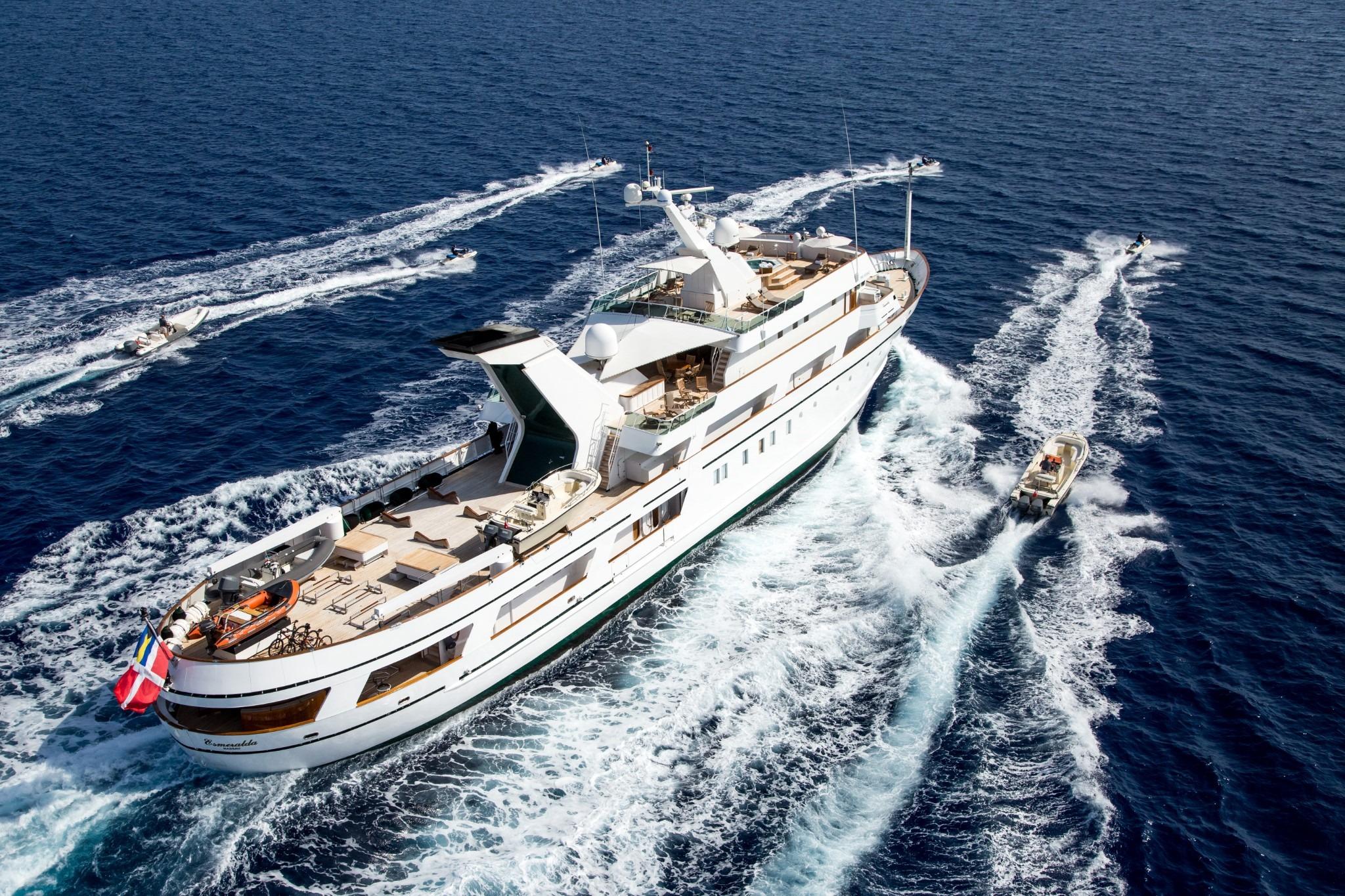 Luxurious 1981 Codecasa ESMERALDA yacht cruising with escort boats on open sea.