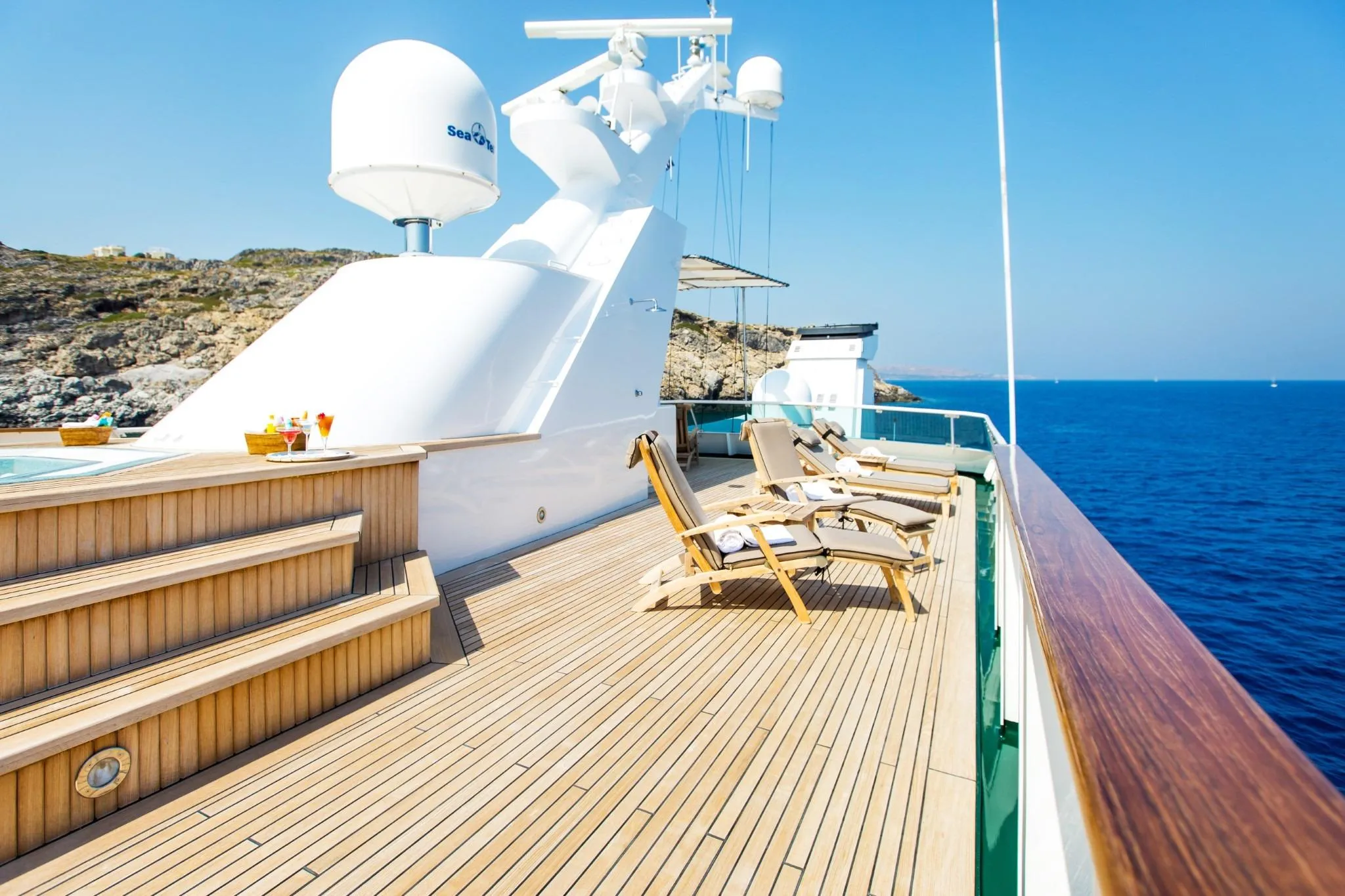 Luxurious Codecasa ESMERALDA yacht deck with sun loungers, ocean view, and clear blue sky.