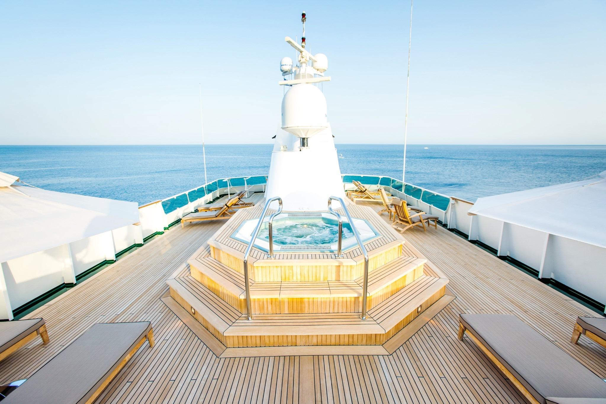 Luxurious deck of Codecasa ESMERALDA yacht, 1981, featuring a central jacuzzi and ocean view.