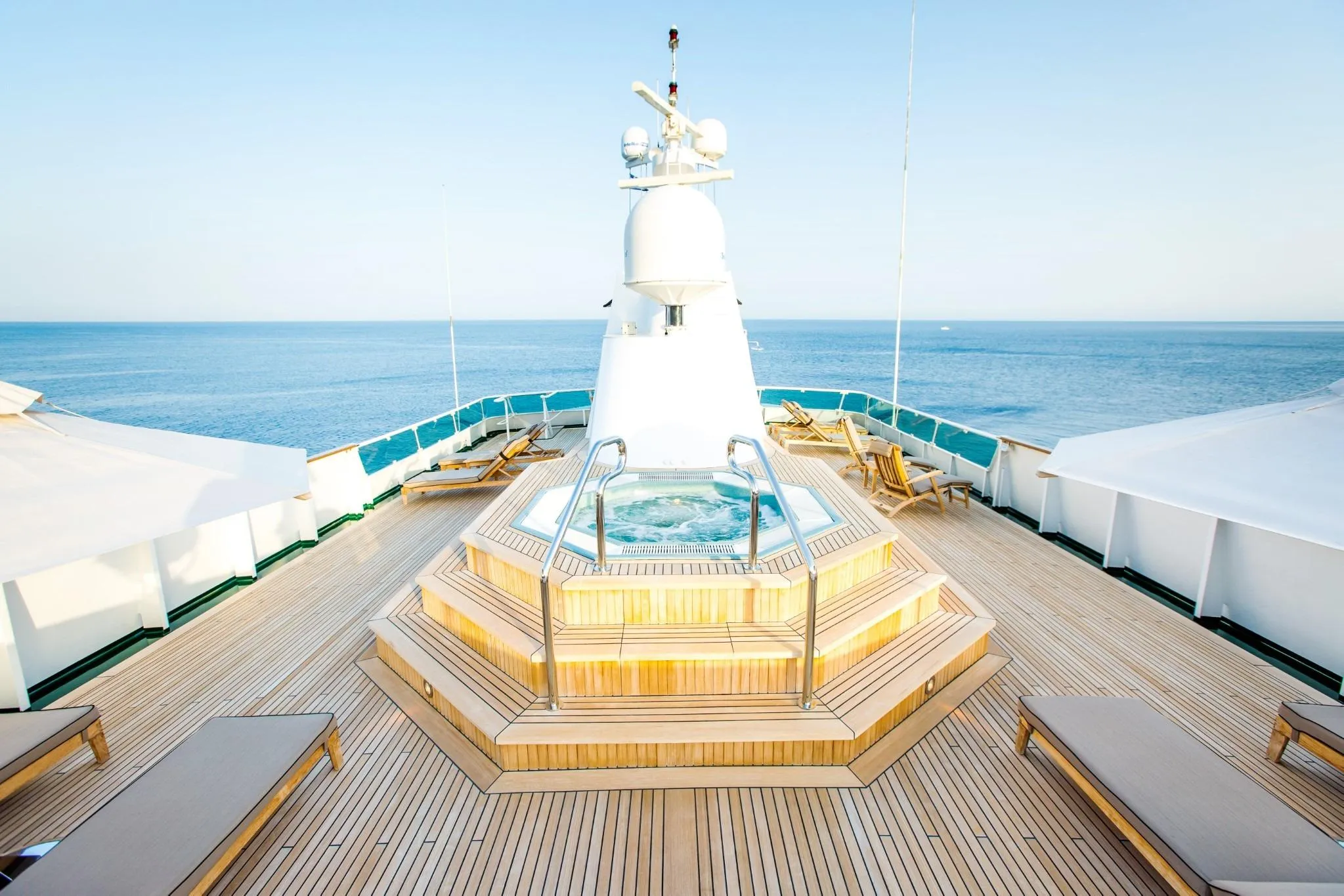 Luxurious deck of Codecasa ESMERALDA yacht, 1981, featuring a central jacuzzi and ocean view.