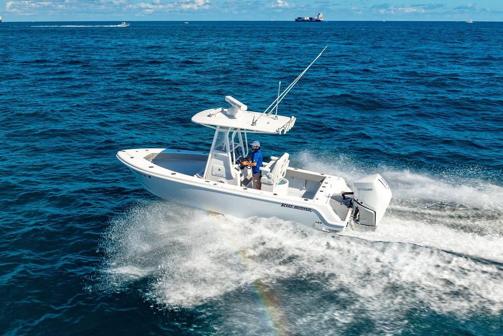 2026 Reef Runner 230 boat cruising on open ocean waters.