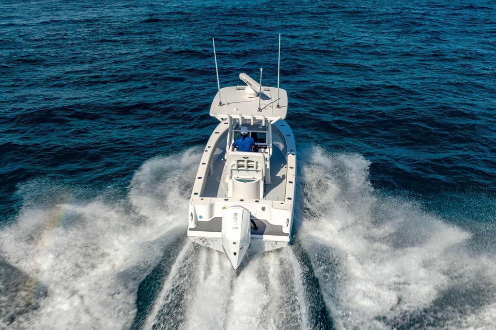 2026 Reef Runner 230 boat cruising on open ocean waters.