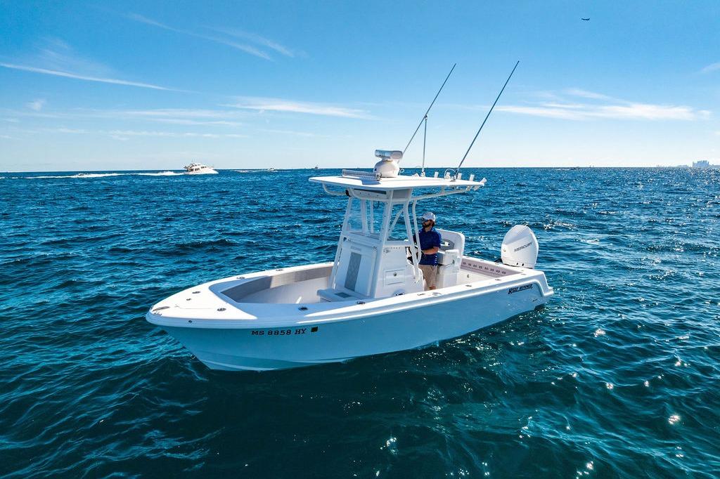 2026 Reef Runner 230 boat cruising on open ocean under clear blue sky.