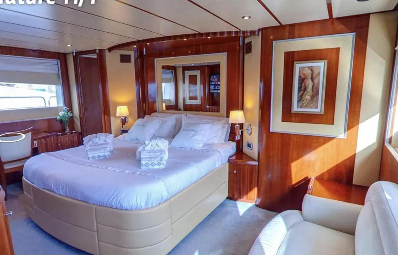 Naughty By Nature Yacht Photos Pics Luxurious bedroom interior of 2002 Rizzardi 105 yacht with elegant wood paneling and plush bedding.