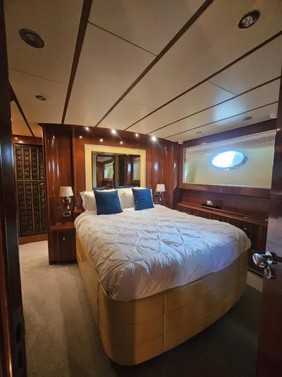 Naughty By Nature Yacht Photos Pics Luxurious bedroom on a 2002 Rizzardi 105 yacht with elegant wood paneling and plush bedding.