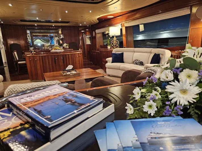 Naughty By Nature Yacht Photos Pics Luxurious interior of 2002 Rizzardi 105 yacht with elegant seating and floral arrangement.