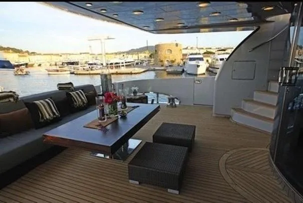 Naughty By Nature Yacht Photos Pics Luxurious 2002 Rizzardi 105 yacht deck with elegant seating and scenic marina view.