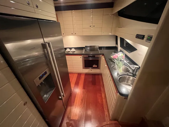 Lidia Yacht Photos Pics Luxurious kitchen in 2006 Ferretti Yachts 830 with modern appliances and wood flooring.