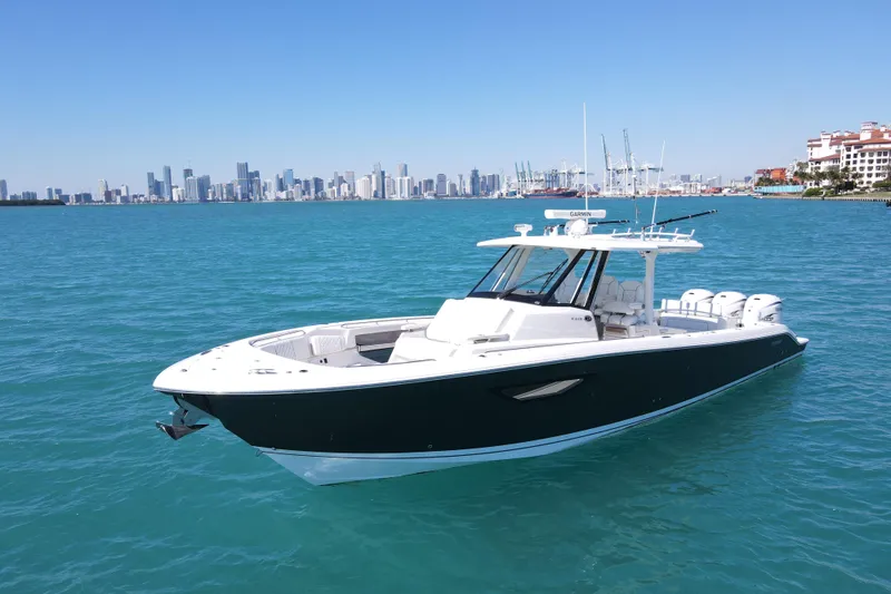  Yacht Photos Pics 2021 Pursuit S 378 Sport boat on blue water with city skyline background.