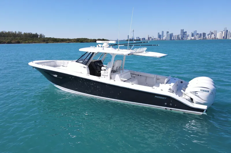  Yacht Photos Pics 2021 Pursuit S 378 Sport boat on turquoise water with city skyline background.