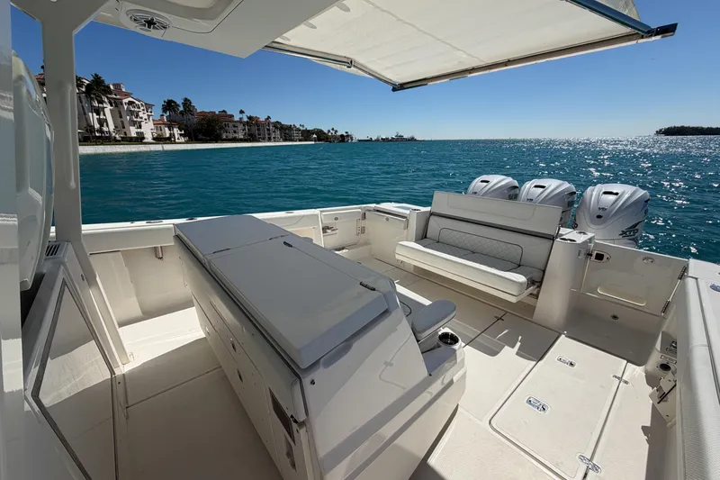  Yacht Photos Pics 2021 Pursuit S 378 Sport boat interior with seating, ocean view, and triple engines.