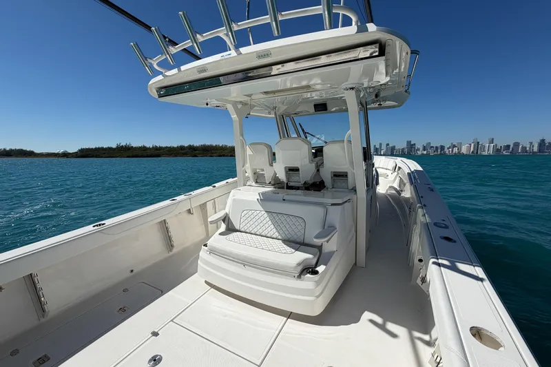  Yacht Photos Pics 2021 Pursuit S 378 Sport boat on blue water with city skyline in background.