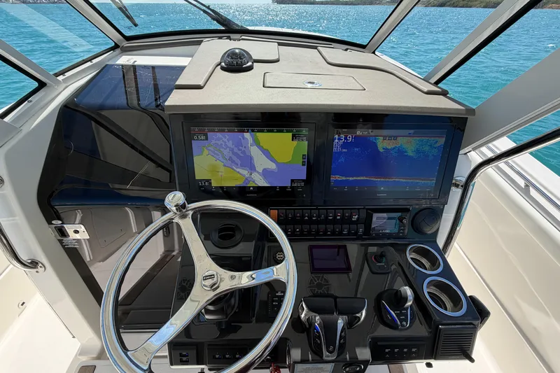  Yacht Photos Pics 2021 Pursuit S 378 Sport boat dashboard with navigation screens and steering wheel.