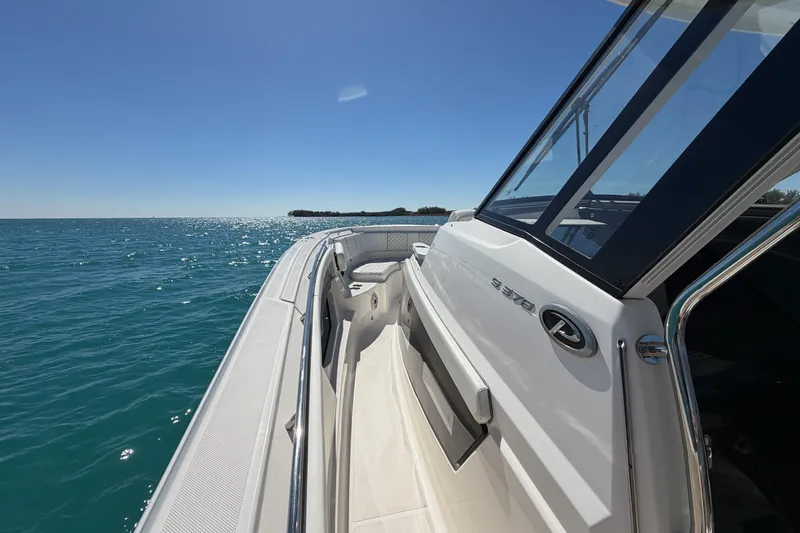  Yacht Photos Pics 2021 Pursuit S 378 Sport boat cruising on clear blue water under a sunny sky.