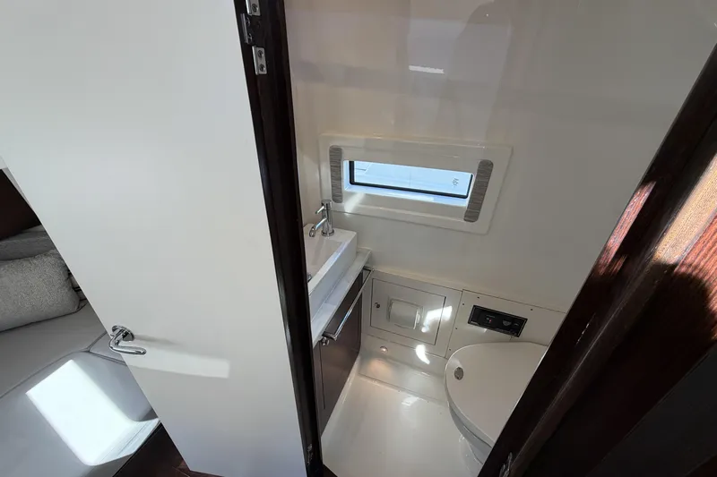  Yacht Photos Pics 2021 Pursuit S 378 Sport boat interior bathroom with sink, toilet, and window.