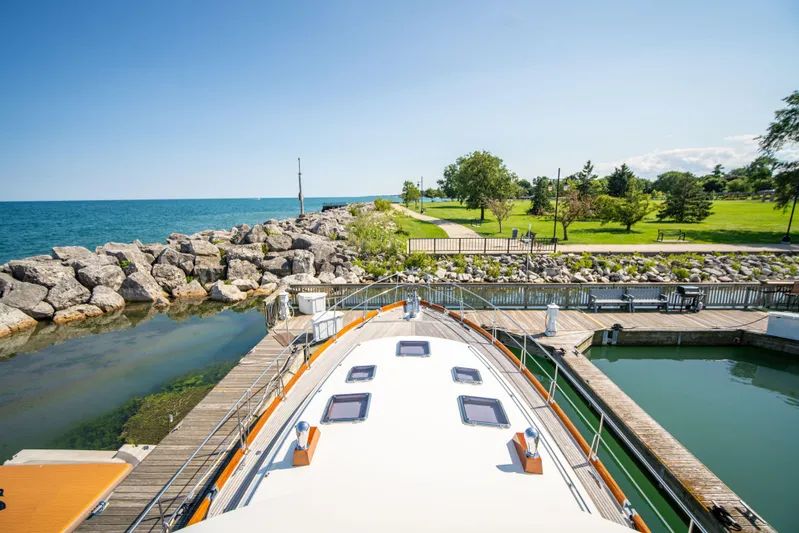 Halcyon Yacht Photos Pics Grand Banks 58 Eastbay FB 2004 yacht docked by a scenic waterfront park.