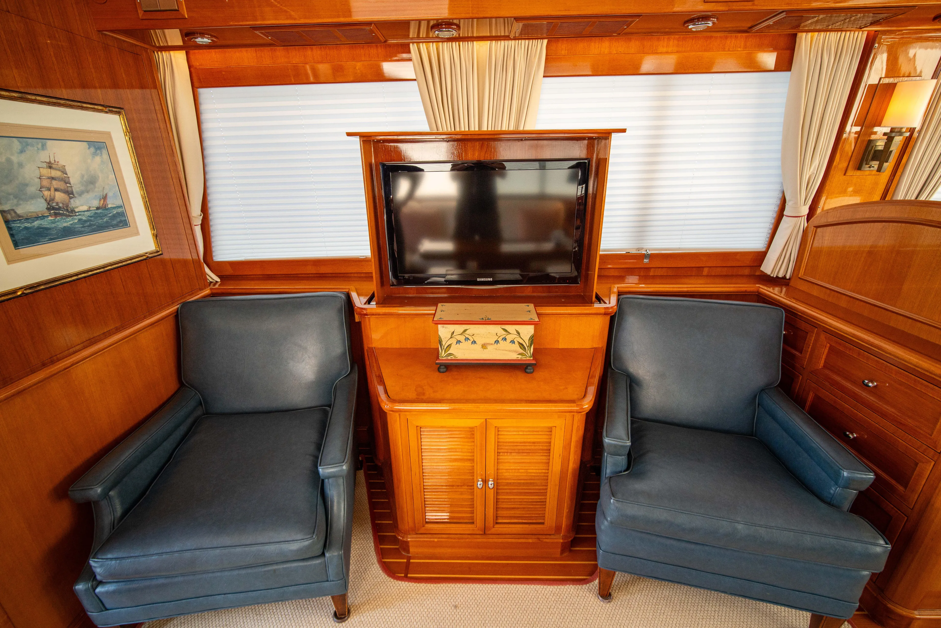 Halcyon Yacht Photos Pics Luxurious 2004 Grand Banks 58 Eastbay FB yacht interior with TV and blue armchairs.