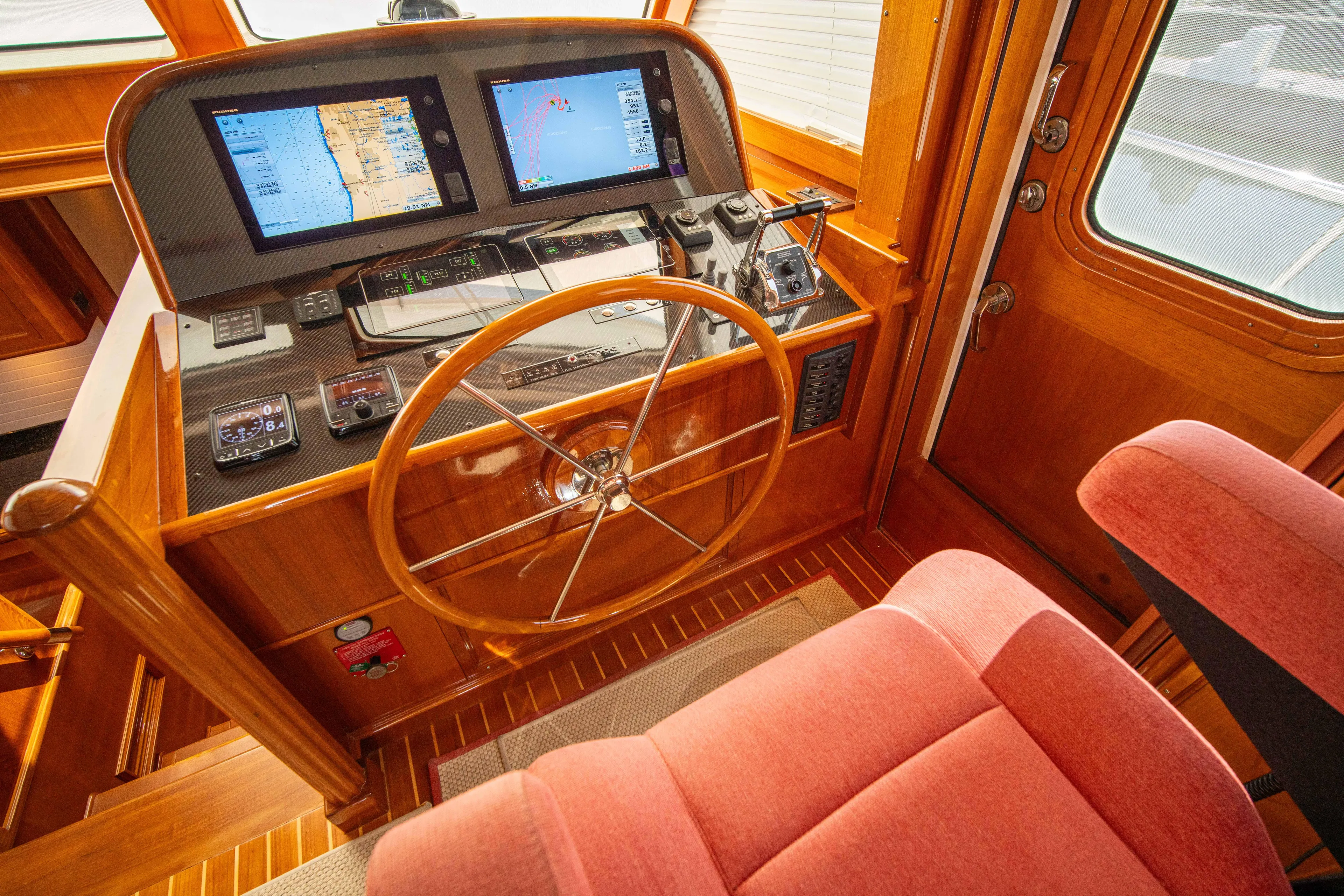 Halcyon Yacht Photos Pics Helm of 2004 Grand Banks 58 Eastbay FB with navigation screens and wooden steering wheel.