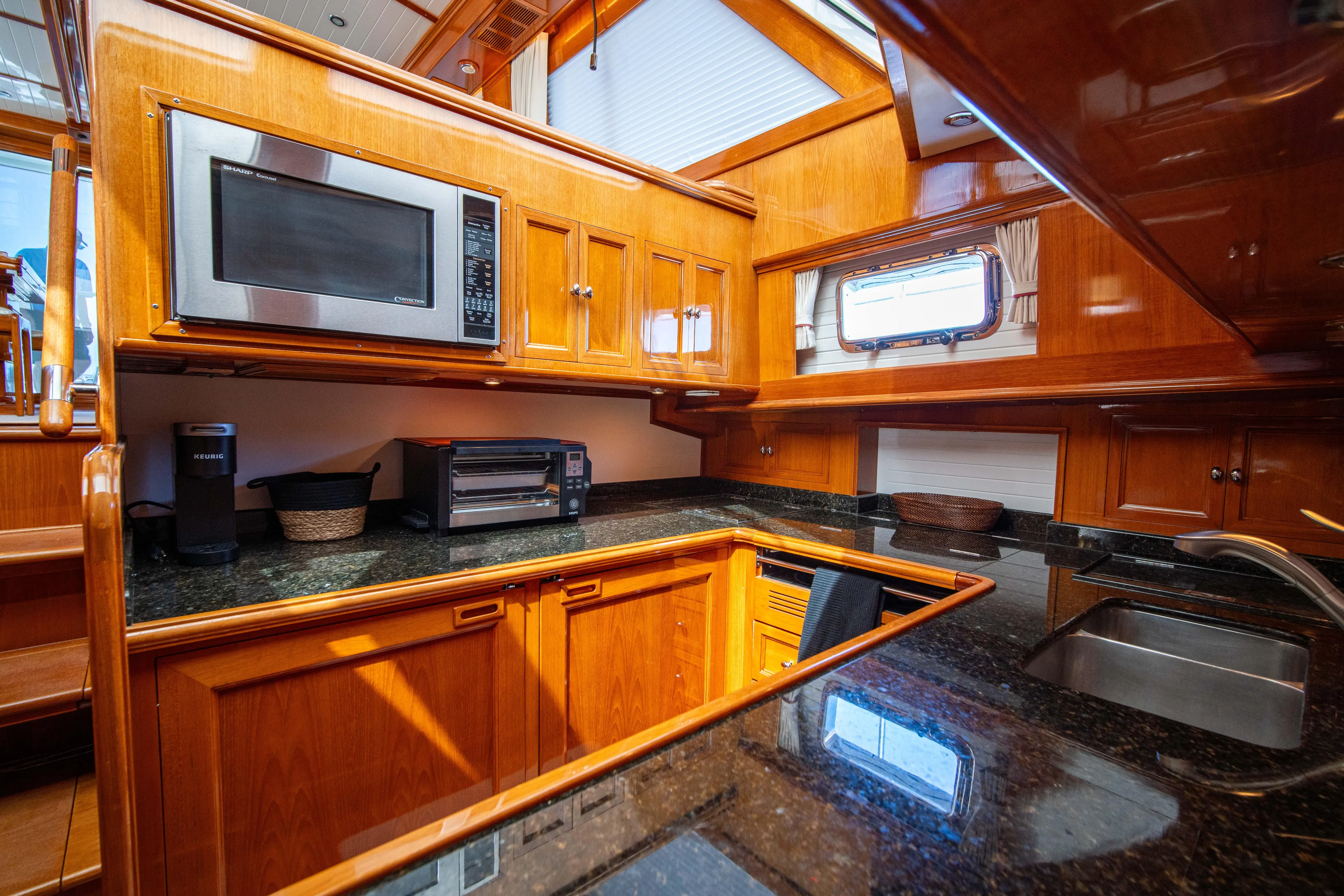 Halcyon Yacht Photos Pics Luxurious kitchen interior of 2004 Grand Banks 58 Eastbay FB yacht with wooden cabinetry.