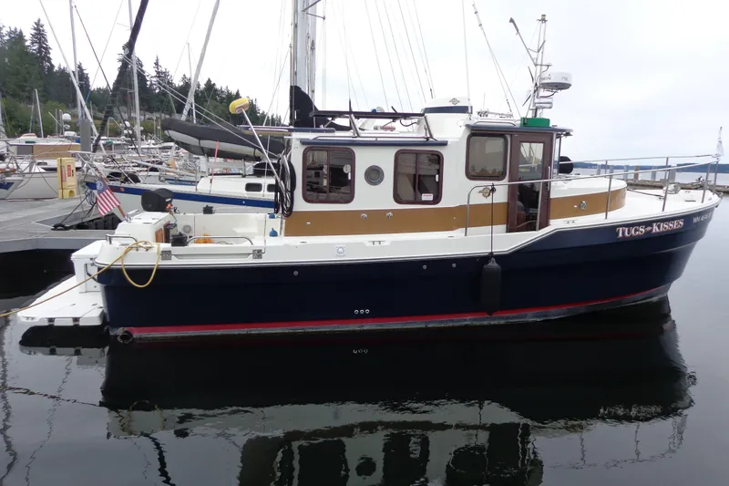 Tugs-n-kisses And Triple Axle Trailer Yacht Photos Pics 2011 Ranger Tugs R-29 Classic boat docked, featuring a sleek design and trailer.