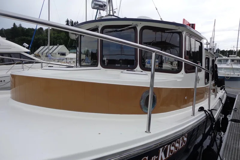 Tugs-n-kisses And Triple Axle Trailer Yacht Photos Pics 2011 Ranger Tugs R-29 Classic boat docked, featuring sleek design and polished railings.