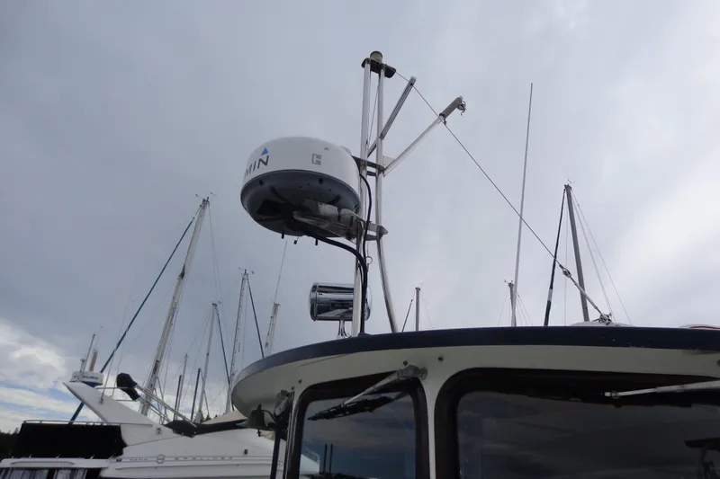 Tugs-n-kisses And Triple Axle Trailer Yacht Photos Pics 2011 Ranger Tugs R-29 Classic boat with radar equipment against cloudy sky.