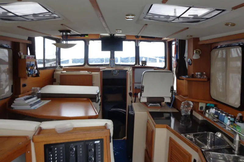 Tugs-n-kisses And Triple Axle Trailer Yacht Photos Pics Interior of 2011 Ranger Tugs R-29 Classic boat, featuring kitchen and seating area.