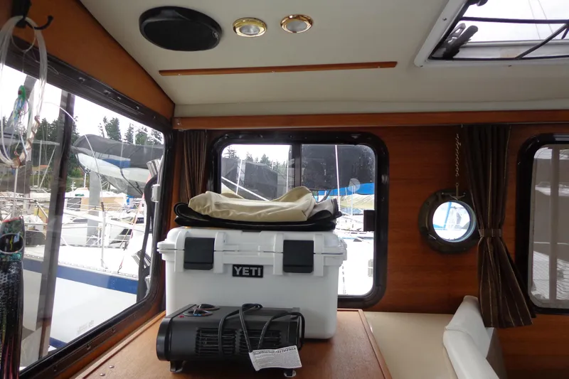 Tugs-n-kisses And Triple Axle Trailer Yacht Photos Pics Interior of 2011 Ranger Tugs R-29 Classic, featuring a Yeti cooler and scenic marina view.