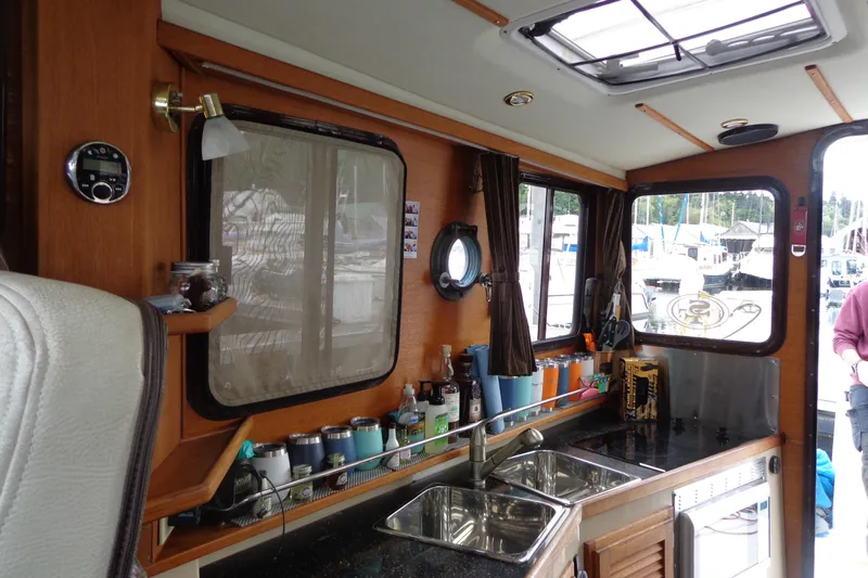 Tugs-n-kisses And Triple Axle Trailer Yacht Photos Pics Interior of 2011 Ranger Tugs R-29 Classic, featuring kitchen area with sink and windows.