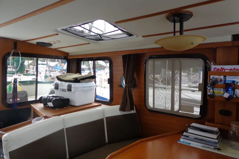 Tugs-n-kisses And Triple Axle Trailer Yacht Photos Pics Interior of 2011 Ranger Tugs R-29 Classic, featuring seating and windows with marina view.