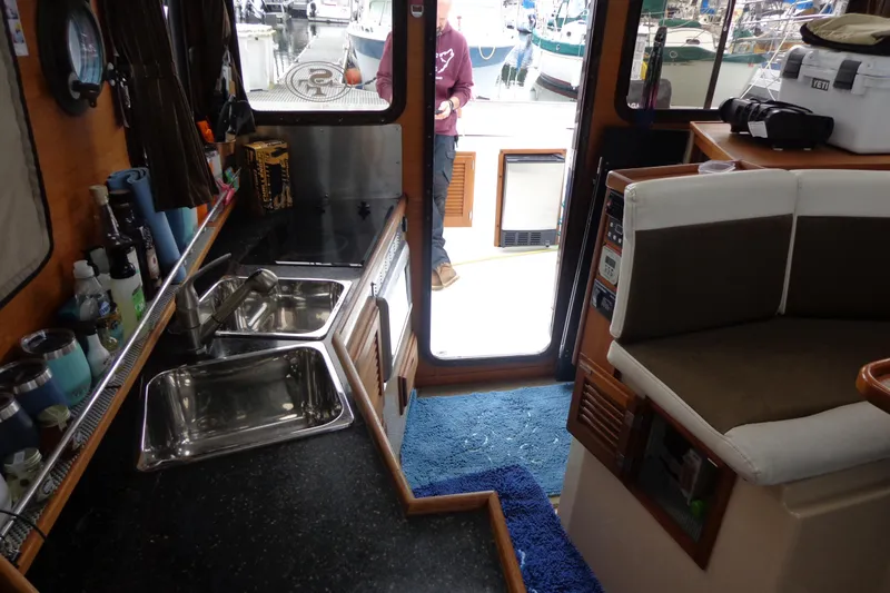 Tugs-n-kisses And Triple Axle Trailer Yacht Photos Pics Interior of 2011 Ranger Tugs R-29 Classic, featuring kitchen and seating area.