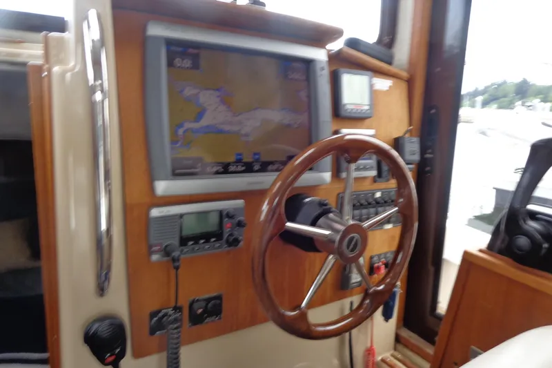 Tugs-n-kisses And Triple Axle Trailer Yacht Photos Pics 2011 Ranger Tugs R-29 Classic helm with navigation equipment and wooden steering wheel.