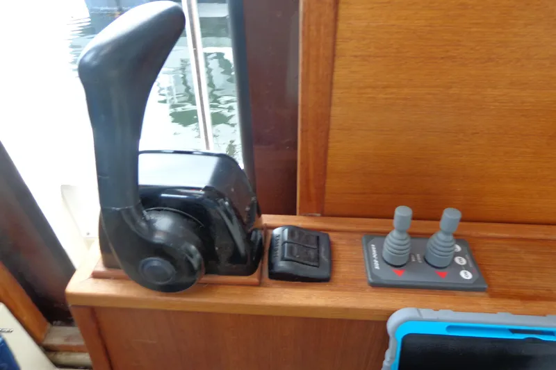 Tugs-n-kisses And Triple Axle Trailer Yacht Photos Pics 2011 Ranger Tugs R-29 Classic boat controls with throttle and joystick on wooden panel.