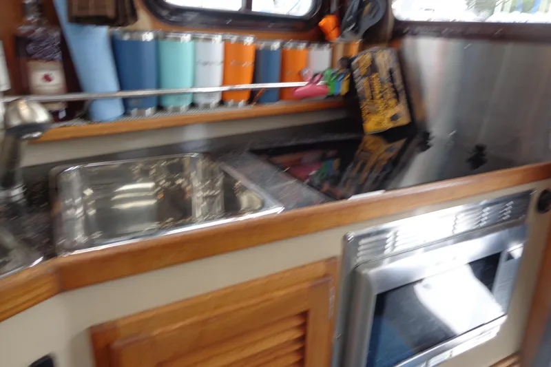 Tugs-n-kisses And Triple Axle Trailer Yacht Photos Pics 2011 Ranger Tugs R-29 Classic interior kitchen with sink, stove, and storage.