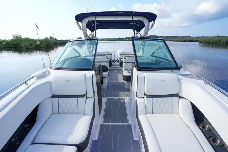  Yacht Photos Pics 2023 Regal 29 OBX boat interior with luxurious seating on a calm lake.
