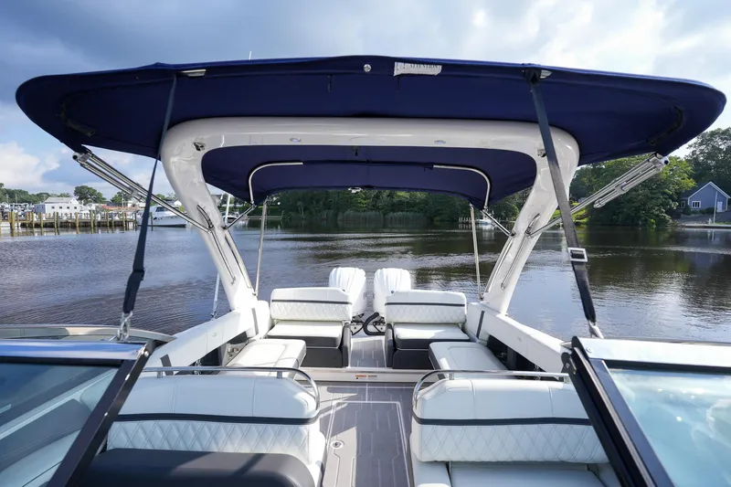  Yacht Photos Pics 2023 Regal 29 OBX boat interior with canopy, docked on a serene lake.